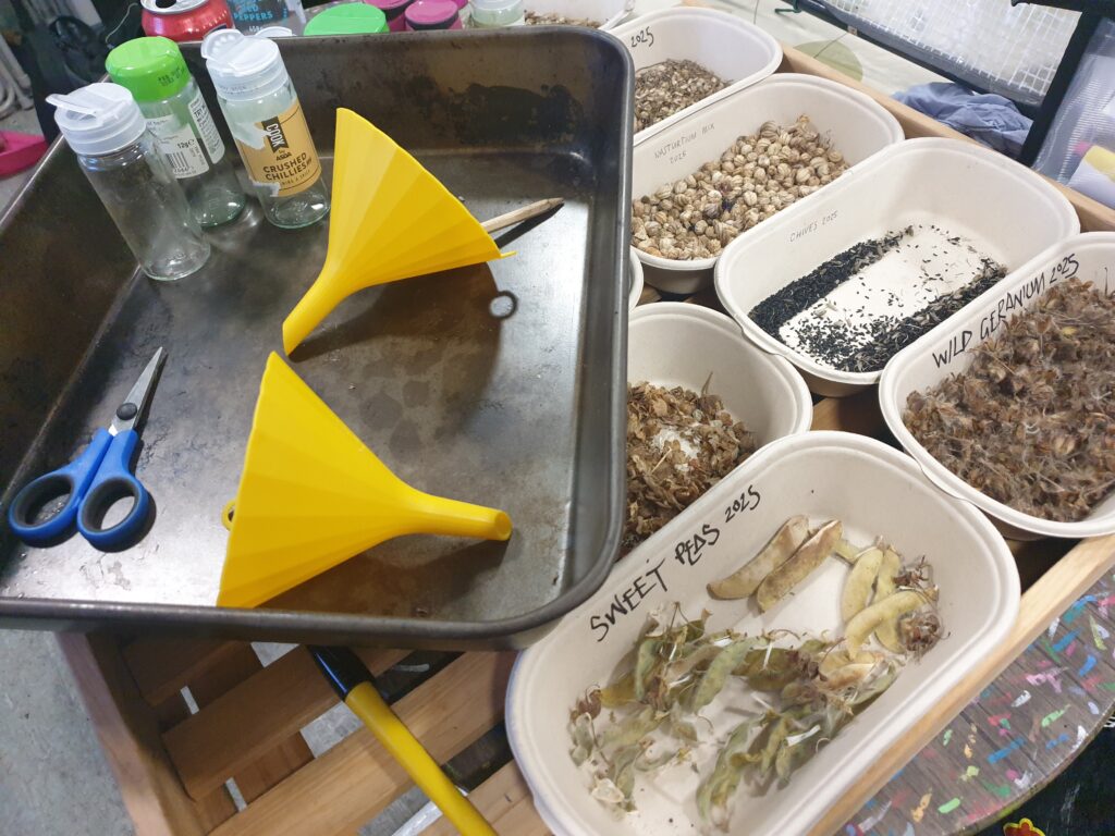 Funnels, scissors, pots, and trays of seeds.